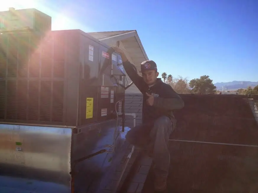 HVAC technician performing Boiler Repair on a rooftop unit in Bellview